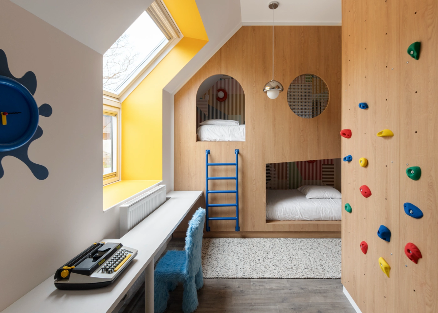 Airbnb déco chambre kids : mur d'escalade coloré, alcôves bunk beds sur mesure en bois et velux habillé jaune, Côte d'Émeraude
