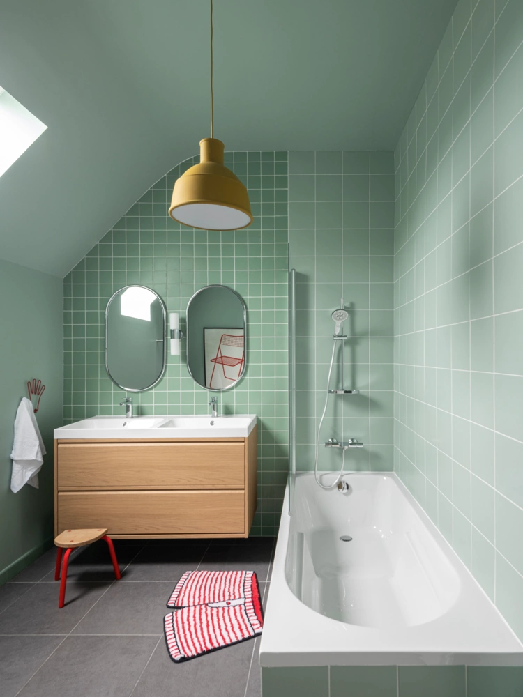 Airbnb déco salle de bain vert sauge : carrelage mur et sol, double vasque bois et baignoire, logement saisonnier Bretagne