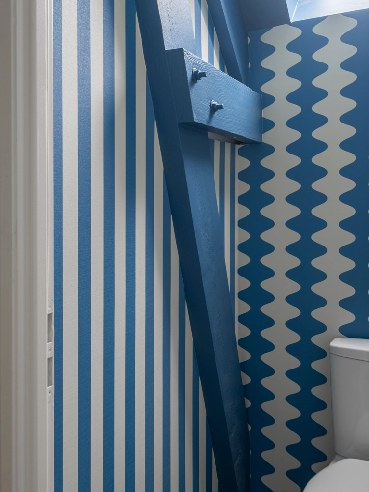 Airbnb déco couloir rayures bleues et WC graphique : traitement mural assumé de A à Z, gîte kids friendly Côte d'Émeraude