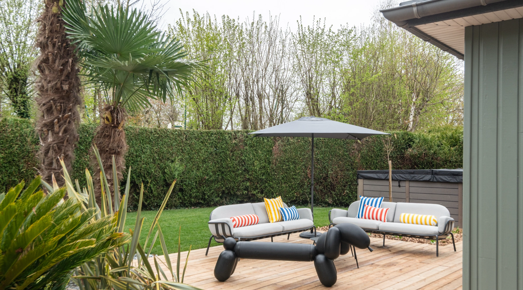 Airbnb déco extérieur : salon de jardin, palmiers et terrasse bois, logement saisonnier haut de gamme Bretagne
